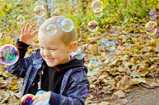 Joyful Child Playing With Bubbles
