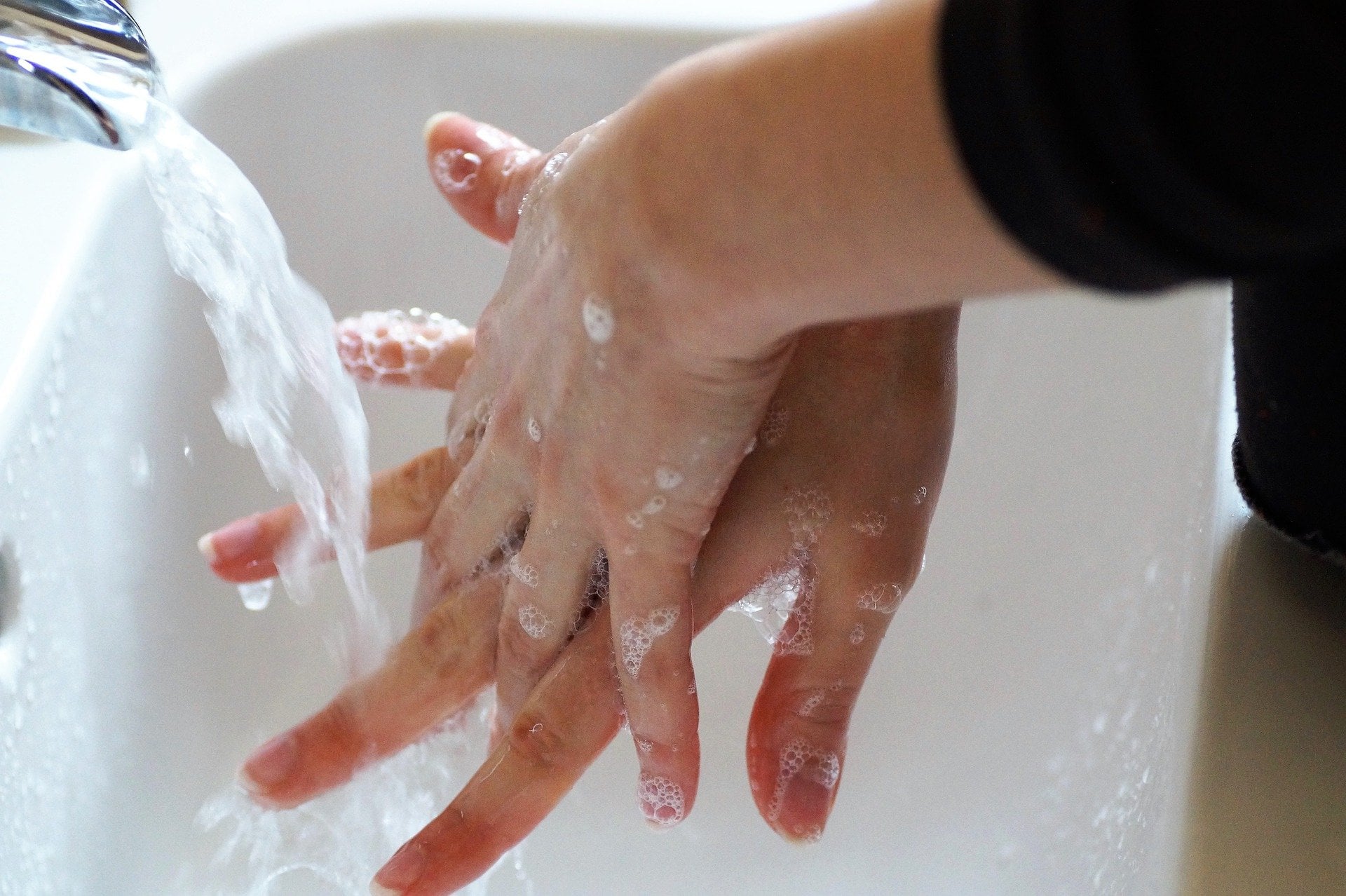 Hands Under Running Water image in article How to Create a Safe and Healthy Child Care Environment