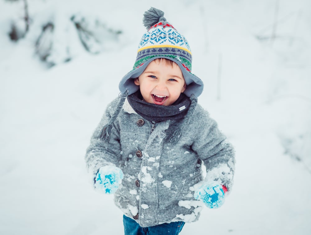 Joyful Child Playing in Winter Wonderland